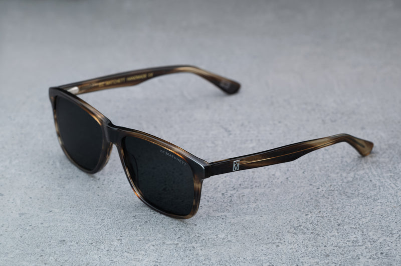 dark brown glasses with dark gray lenses, open, facing left showing a quartering view.