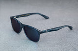 dark blue sunglasses with reflective green lenses, open, facing left showing a quartering view.