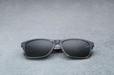 dark brown glasses with dark gray lenses, laying flat, facing forward.