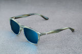 Light green sunglasses with reflective blue lenses, open, facing left showing a quartering view.